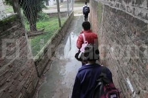 ELLITORAL_95466 | Mauricio Garín Como puedan. Así deben salir los chicos, en el pasillo transformado en arroyo por un gran charco.