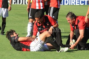 Amancio Alem. Un médico por favor. El Dr. Eduardo Lalo Vega, ex futbolista sabalero, atiende en el piso del Cementerio de los Elefantes a Ronald Raldes. Fue el sábado, en el partido contra Estudiantes de La Plata. Se cayó solo el zaguero y sufrió un insólito desgarro que lo alejará de las canchas por casi un mes.