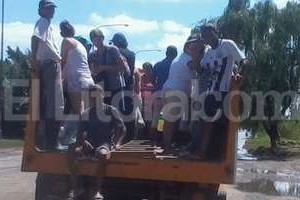 ELLITORAL_117520 |  Mauricio Garín Los vecinos buscan provisiones en los camiones municipales.