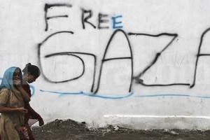 ELLITORAL_99913 |  agencia EFE. Dos mujeres cachemires caminan por delante de un graffiti durante una jornada de huelga en Srinagar, India, en protesta por los bombardeos en la franja de Gaza.