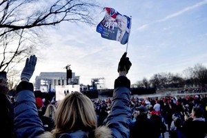 ELLITORAL_171575 |  DPA Una mujer agita una bandera con el rostro de Donald Trump, en señal de apoyo durante su investidura.
