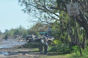 ELLITORAL_160747 |  Flavio Raina Niños entre la basura, en Gral. Paz al noreste de la ciudad, pese al cartel que indica no arrojar...