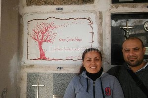Fotos de hinchas de Colón pintando el nicho del pibe en el cementerio.