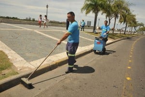 ELLITORAL_203221 |  Guillermo Di Salvatore El faro. Alberto Ramos (adelante) y Jorge Suárez, que hace más de una década que trabajan para Cliba, barren uno de los tramos de la costanera que los fines de semana más basura acumula.
