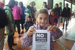 ELLITORAL_149377 |  Flavio Raina Volante. La niña muestra el reclamo por escrito emitido por la vecinal de Colastiné Norte. La concentración fue esta mañana, bajo una copiosa lluvia.