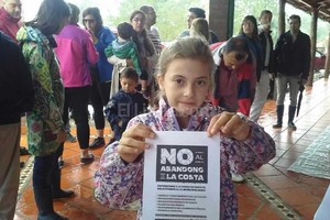 ELLITORAL_149377 |  Flavio Raina Volante. La niña muestra el reclamo por escrito emitido por la vecinal de Colastiné Norte. La concentración fue esta mañana, bajo una copiosa lluvia.
