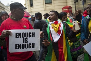 ELLITORAL_218144 |  Archivo Un ciudadano de Zimbabue porta un cartel con la inscripción "suficiente es suficiente". Los manifestantes apoyan el golpe de Estado militar de esta semana en Zimbabue y exigen la dimisión del presidente Robert Mugabe, que se encuentra bajo arresto domiciliario en la capital Harare. foto: Ben Stevens/PA Wire/dpa