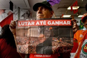 ELLITORAL_208111 |  DPA Luchar hasta ganar , dice el cartel que alza un manifestante en la central del sindicato metalúrgico en Sao Paulo.