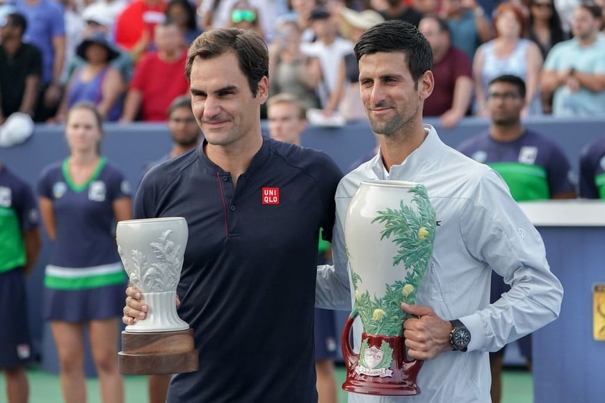 ELLITORAL_220207 |  dpa El tenista suizo Roger Federer (izq.) y el serbio Novak Djokovic (der.) posan con sus trofeos después de que Djokovic derrotara a Federer en la final de tenis masculino del torneo de tenis Cincinnati