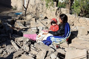 ELLITORAL_195513 |  EFE Una mujer permanece junto a su hija junto a los restos de un edificio dañado tras el terremoto.
