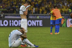ELLITORAL_252760 |  Télam Argentina's Leandro Paredes (on the ground) and Juan Foyth show their dejection after losing 2- to Brazil at the end of their Copa America football tournament semi-final match at the Mineirao Stadium in Belo Horizonte, Brazil, on July 2, 2019. (Photo by Nelson ALMEIDA / AFP)
