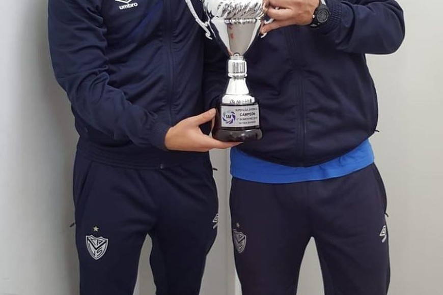 ELLITORAL_256390 |  Gentileza Prensa Vélez Política de Estado. Una de las alegrías, donde el  Chino  Ariel Zárate levanta la copa de su división. Durante los dos años de Fanessi, Vélez fue segundo en la tabla general de inferiores. Cuando Sebastián Pait volvió de Talleres, Vélez mejoró: fue número 1 durante los últimos dos años. Hoy, la pelea es mano a mano con Lanús para ver quién trabaja mejor.