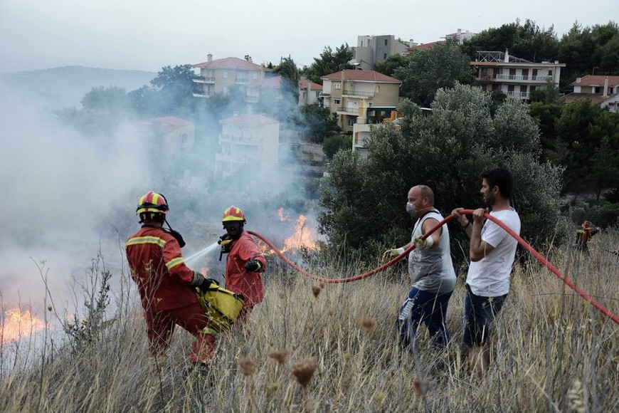 ELLITORAL_217699 |  dpa Los bomberos intentan extinguir las llamas en la región de Kinetta, 40 kilómetros al oeste de Atenas, Grecia, el 23/07/2018. Las fuertes sequías favorecieron un incendio forestal que se propagó a raíz de fuertes vientos. Grecia atraviesa un verano con temperaturas de hasta 40 grados. (Vinculado al texto de dpa "Gran incendio forestal en Grecia está fuera de control"). Foto: Giorgios Zachos/SOPA Images via Zuma /dpa +++ dpa-fotografia +++