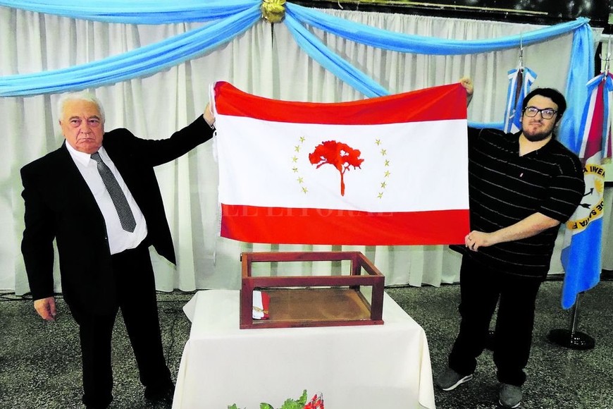 ELLITORAL_199359 |  Manuel Mudry El senador Osvaldo Sosa junto a Mario Javier Zalazar, quien realizó el diseño ganador, exhiben por primera vez la Bandera Departamental.