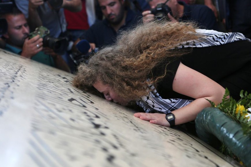 ELLITORAL_218139 |  dpa La adolescente palestina Ahed Tamimi besa la lápida de la tumba del fallecido líder palestino Yassir Arafat en Ramala, Territorios Palestinos, tras ser liberada de la cárcel en Israel el 29/07/2018.