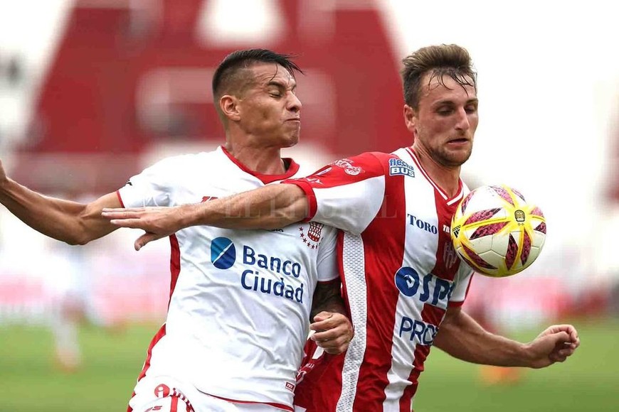 ELLITORAL_239041 |  El Litoral Bruno Pittón, de gran primer tiempo, cubre la pelota ante la presencia de Auzqui, quien sobre el final de esa etapa le sacó chispas al travesaño con un remate desde afuera del área.