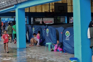 ELLITORAL_223230 |  dpa Filipinas, Manila: Familias filipinas aguardan dentro de tiendas de campaña en un campamento de evacuados.