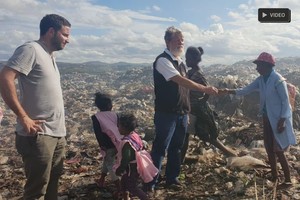 Gentileza Opeka. En la fotografía, Vigo junto al sacerdote y un grupo de gente a la que ayudan a salir de la pobreza.