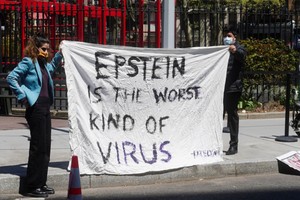Reuters Manifestantes sostienen una pancarta frente al Tribunal Federal de Manhattan antes de la lectura de cargos de Ghislaine Maxwell en una nueva acusación, en el distrito de Manhattan de la ciudad de Nueva York, Nueva York, EE. UU., 23 de abril de 2021.