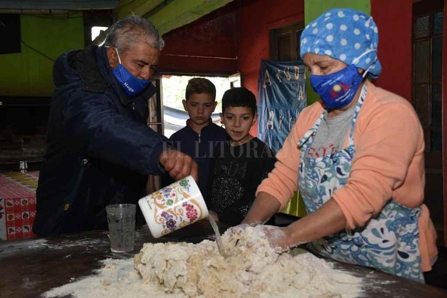 ELLITORAL_321191 |  Manuel Fabatía Ante la atenta mirada de 2 de sus ¡17 nietos!, Hugo le tira agua tibia a Susana en las manos mientras amasa el pan casero.