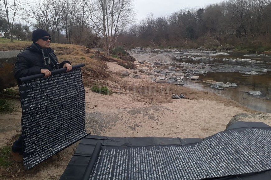 ELLITORAL_392146 |  Gentileza Daniel Kuryj Daniel en una performance con poemas sobre cartulinas (Río San Antonio, Córdoba, 2019).