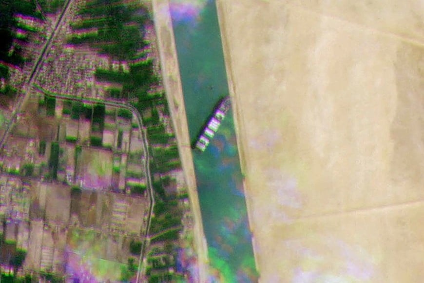 ELLITORAL_365269 |  Gentileza A satellite handout image released by Planet Labs Inc on March 24, 2021, shows the Taiwan-owned MV 'Ever Given' (Evergreen) container ship, a 400-metre- (1,300-foot-)long and 59-metre wide vessel, lodged sideways and impeding all traffic across the waterway of Egypt's Suez Canal. - A giant container ship ran aground in the Suez Canal after a gust of wind blew it off course, the vessel's operator said on March 24, 2021, bringing marine traffic to a halt along one of the world's busiest trade routes. (Photo by - / Planet Labs / AFP) / RESTRICTED TO EDITORIAL USE - MANDATORY CREDIT "AFP PHOTO / PLANET LABS " - NO MARKETING - NO ADVERTISING CAMPAIGNS - DISTRIBUTED AS A SERVICE TO CLIENTS