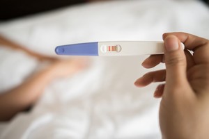 Gentileza Young woman hand holding pregnancy test