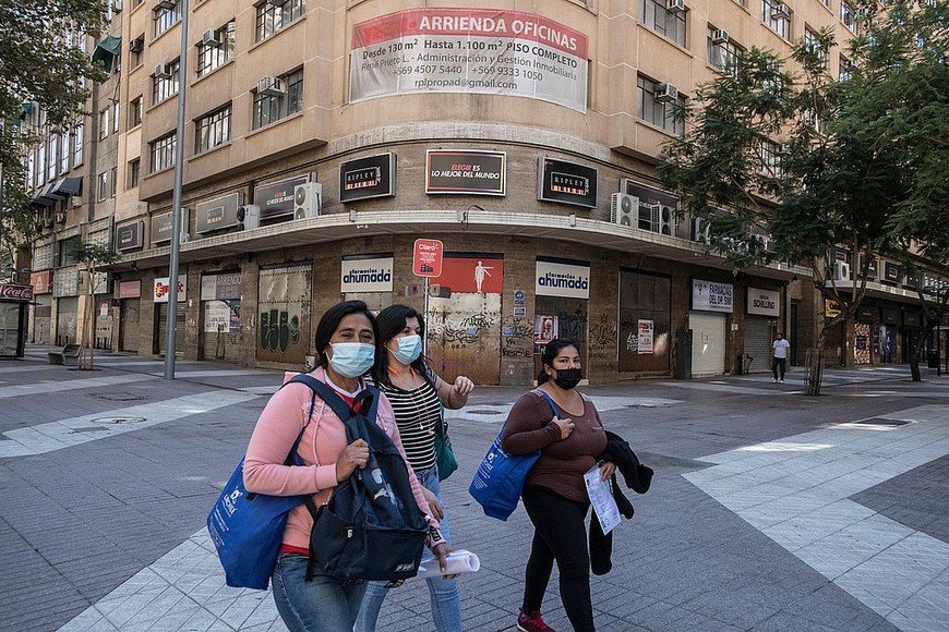 ELLITORAL_366233 |  Xinhua/Jorge Villegas Mujeres caminan frente a locales comerciales cerrados durante el confinamiento decretado para detener la propagación del coronavirus, en Santiago, capital de Chile