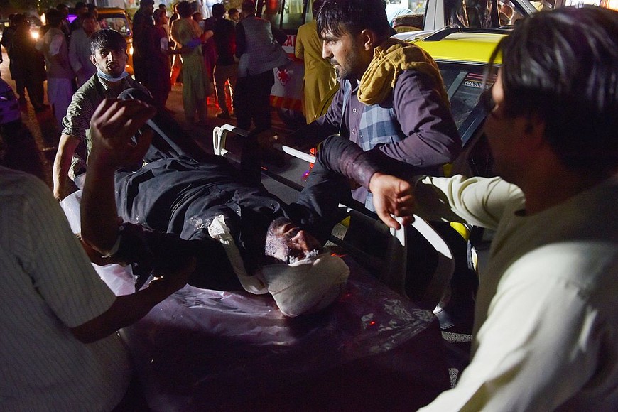 ELLITORAL_399749 |  WAKIL KOHSAR El personal médico y hospitalario lleva a un hombre herido en una camilla para recibir tratamiento después de dos explosiones, en las que murieron al menos cinco e hirió a una docena, frente al aeropuerto de Kabul el 26 de agosto de 2021 (Foto de Wakil KOHSAR / AFP).