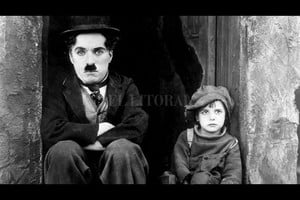 First National Picture Chaplin junto al pequeño Jackie Coogan en una de las escenas de  El pibe . Resultó una de las aventuras más famosas de Charlot, personaje que el británico creó a principios del siglo XX y pobló las pantallas hasta la llegada del cine sonoro.