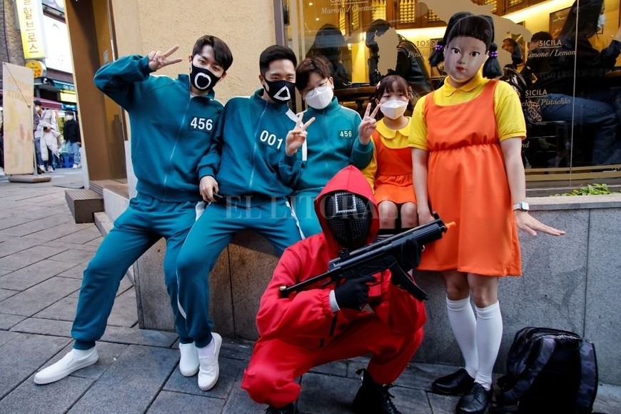 ELLITORAL_414538 |  Reuters Personas vestidas con trajes de ´Squid Game´ de la serie Netflix posan para fotografías en la calle en el centro de Seúl