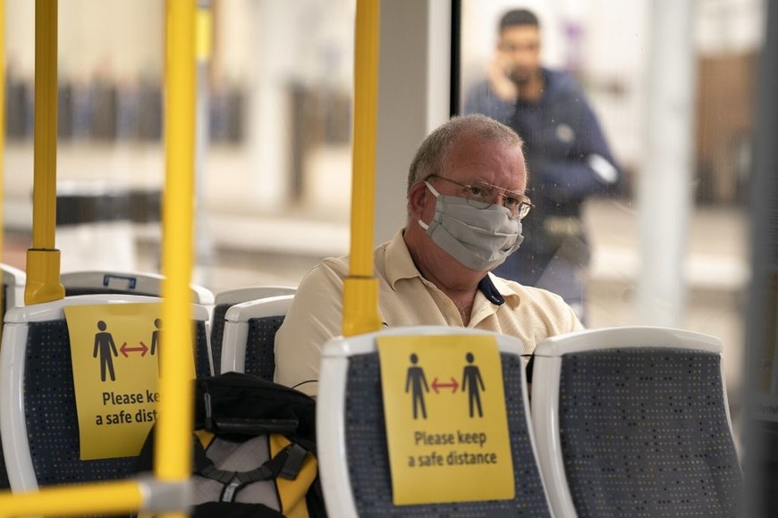 ELLITORAL_311111 |  Gentileza Un hombre portando una mascarilla viaja en un tranvía, en la Estación de Ferrocarril Manchester Victoria, en Manchester