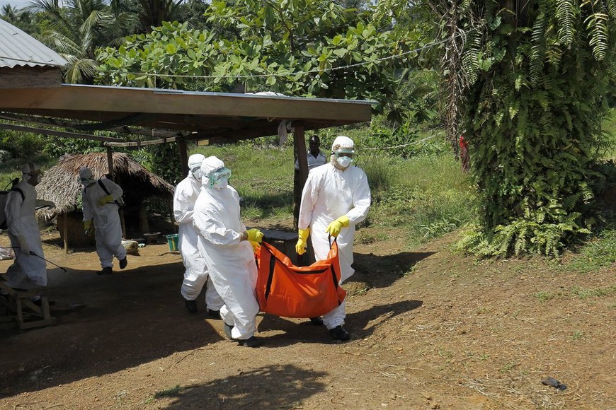 ELLITORAL_247880 |  Archivo MON101. Monrovia (Liberia), 24/10/2014.- A Liberian Red Cross burial team retrieves the body of a suspected victim of Ebola in Banjor, on the outskirts of Monrovia, Liberia 24 October 2014. Latest statistics from the United Nations World Health Organization (WHO) place the death toll from the Ebola virus outbreak at over 4,900, with most of those fatalities in West Africa. The African Union was planning to send more experts to Ebola-affected countries in addition to 36 medical staff already deployed, the World Food Programme WFP regional body's chair Nkosazana Dlamini Zuma said 24 October after a one-day visit to Liberia. EFE/EPA/AHMED JALLANZO