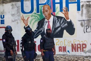 ELLITORAL_392299 |  Gentileza La policía haitiana frente a un mural con imagen del presidente haitiano asesinado, Jovenel Moïse.