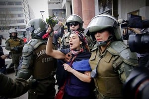 ELLITORAL_191125 |  DPA Una mujer de la comunidad mapuche es detenida el viernes por la Fuerza de Seguridad chilena.
