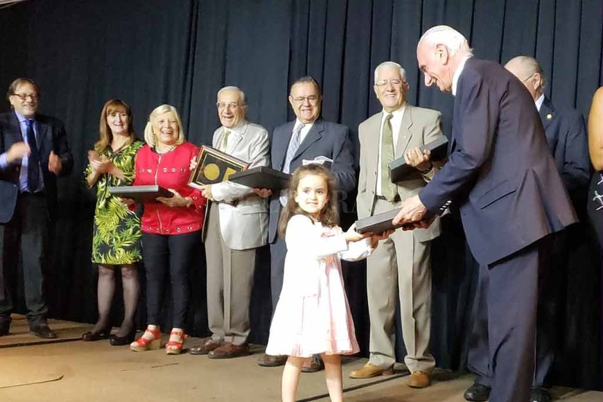 ELLITORAL_235179 | Gentileza De nieta a abuelo. El doctor Gargatagli recibe la plaqueta por sus 50 años de profesión de las manos de su propia nieta Victoria.