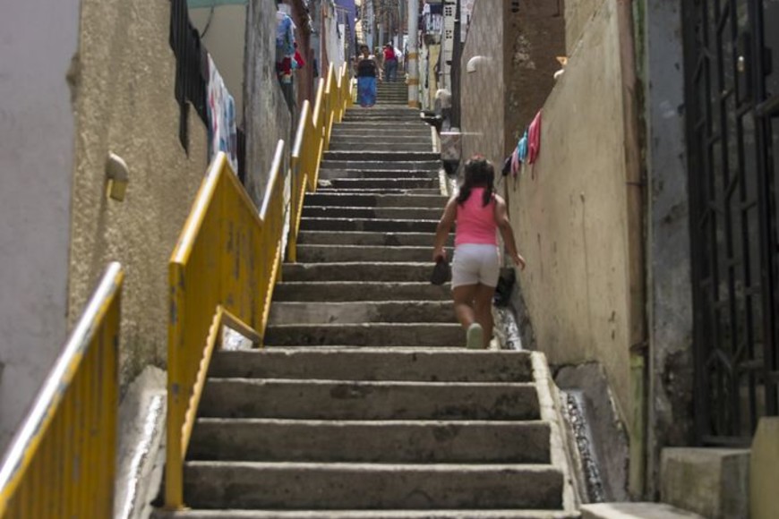 ELLITORAL_230884 |  DPA 21 noviembre 2018, Colombia, Medellin: Una niña recorre una de las calles del barrio "Pablo Escobar". En una colina de Medellín se encuentra una urbanización de amplias casas con jardín, suelos en baldosa y colores relucientes, donde habitan poco más de 16.000 personas que todavía hoy, 25 años después de la muerte de Pablo Escobar, recuerdan con religiosidad al capo que les brindó un techo a los "más necesitados".
(Vinculado al texto de dpa ""Pablo Escobar", el barrio que rinde culto al capo del narcotráfico" del 27/11/2018) Foto: Daniel Romero/dpa +++ dpa-fotografia +++