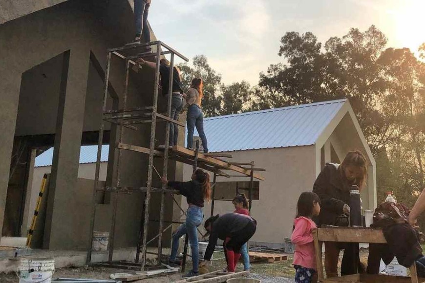 ELLITORAL_426956 |  Gentileza Levantando dignidad. Los futuros habitantes participan, junto a voluntarios, en la construcción de sus viviendas. Gentileza