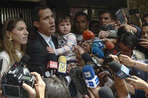 ELLITORAL_236914 |  Télam El líder de la oposición y autoproclamado  presidente interino  Juan Guaido habla con la prensa mientras sostiene a su hija Miranda, junto a su esposa Fabiana Rosales, afuera de su casa.