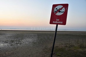 Flavio Raina Quedó lejos. ...Y chiquito, el cartel que indica la prohibición de ingresar a la laguna Setúbal, sobre el solarium de la Costanera Oeste, producto de la bajante.
