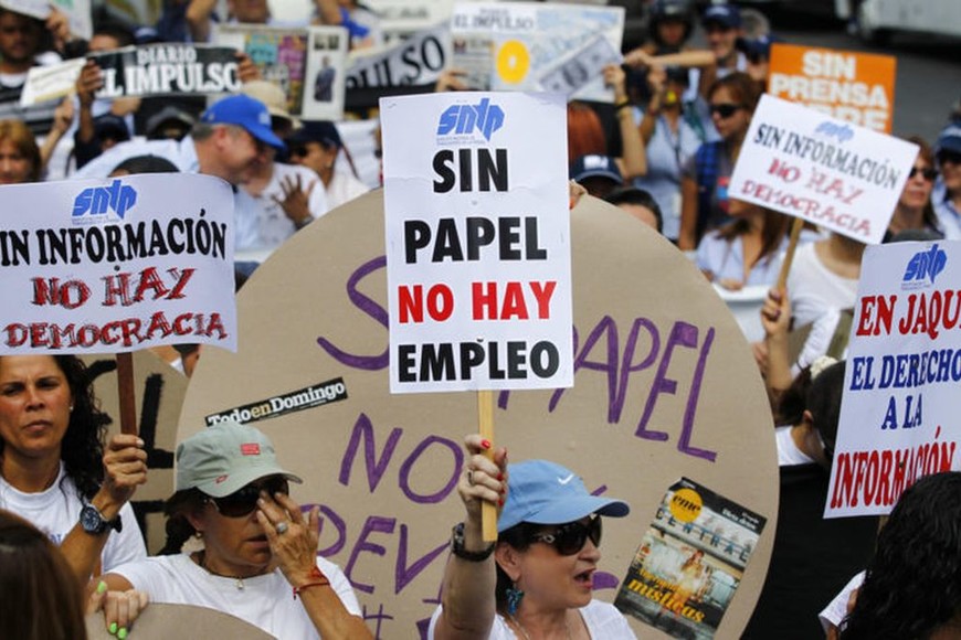 ELLITORAL_221529 |  Carlos Garcia Rawlins A woman holds up a sign reading "No paper, no jobs", during a protest by newspaper workers and opposition parties to demand from the government U.S. dollars at a prime rate to buy paper for their publications, in Caracas February 11, 2014. Newspaper owners claim they are close to running out of their stock of paper due to the lack of dollars to import it, local media said.  REUTERS/Carlos Garcia Rawlins (VENEZUELA - Tags: POLITICS CIVIL UNREST MEDIA BUSINESS EMPLOYMENT)
