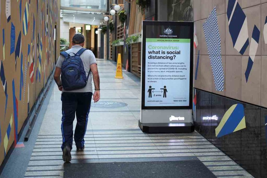 ELLITORAL_311943 |  Imagen ilustrativa A man walks in a corridor near a sign with instructions about the coronavirus and social distancing following the implementation of stricter social-distancing and self-isolation rules to limit the spread of the coronavirus disease (COVID-19) in Sydney, Australia, March 31, 2020.  REUTERS/Loren Elliott