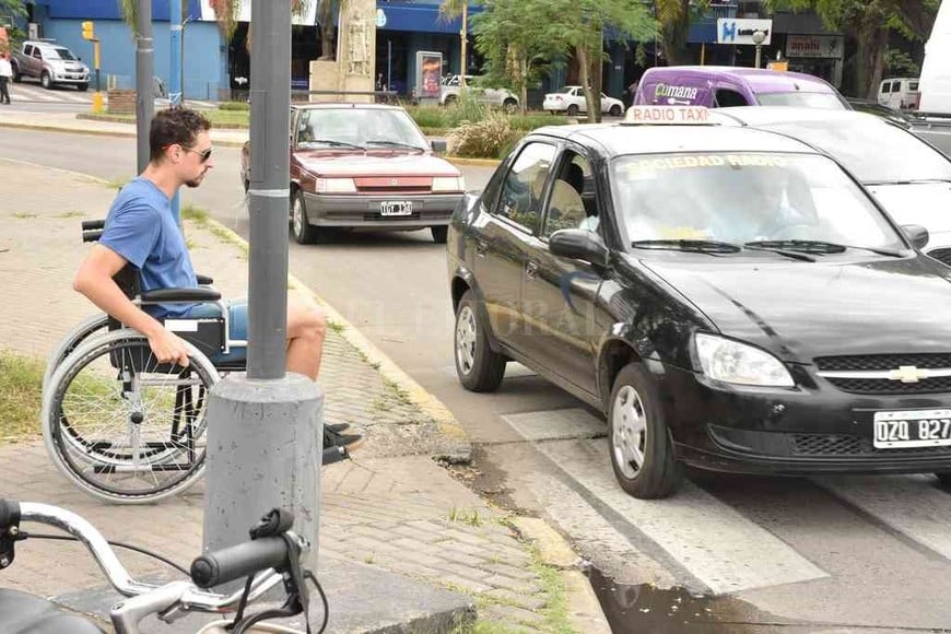ELLITORAL_277753 | Flavio Raina Un muchacho tratando cruzar en silla de ruedas el cruce por Tucumán. El cordón de la rampa, roto. Las fotos son de la actividad realizada en 3 de diciembre, en el marco del Día Internacional de las Personas con Discapacidad.