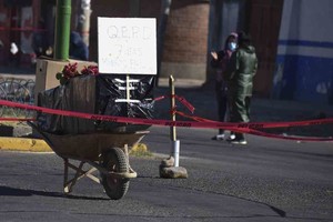 ELLITORAL_312231 |  Agencias Un ataúd envuelto en plástico que contiene los restos de un hombre no identificado y que murió la semana pasada con síntomas de Covid-19 fue colocado en una carretilla en medio de la calle por los familiares para llamar la atención de las autoridades y lograr que sea enterrado, en Cochabamba, Bolivia.