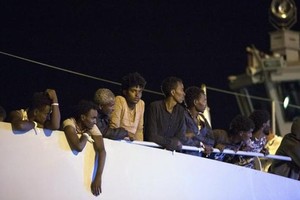 ELLITORAL_220149 |  FRANCESCO RUTA. Varios migrantes esperan antes de desembarcar de la nave de Frontex.