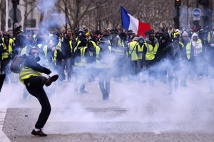 ELLITORAL_232039 |  IAN LANGSDON IAN100. Paris (France), 08/12/2018.- A Yellow Vests protester hurl back tear gas to French riot police during a demonstration in Paris, France, 08 December 2018. Police in Paris is preparing for another weekend of protests of the so-called 'gilets jaunes' (yellow vests) protest movement. Recent demonstrations of the movement, which reportedly has no political affiliation, had turned violent and caused authorities to close some landmark sites in Paris this weekend. (Protestas, Francia) EFE/EPA/IAN LANGSDON