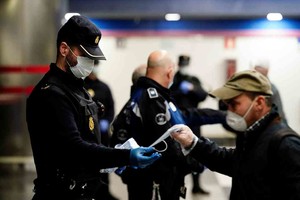 ELLITORAL_295686 |  Reuters A police officer gives out free protective face masks at a metro station during the lockdown amid the coronavirus disease (COVID-19) outbreak in Madrid, Spain, April 13, 2020. REUTERS/Juan Medina