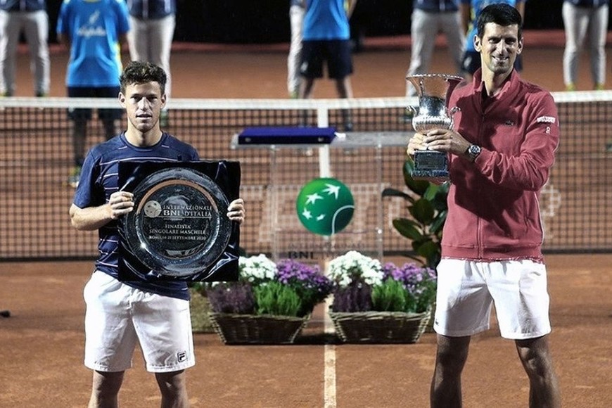 ELLITORAL_326982 |  Gentileza ATP ¡Aplausos...! Schwartzman y Djokovic, con los trofeos correspondientes al segundo y primer lugar del tradicional certamen de la capital italiana.