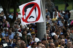 ELLITORAL_212251 |  Ariana Cubillos An anti-government demonstrator waves a flag against Venezuela's President Nicolas Maduro during a vigil in honor of those who have been killed during clashes between security forces and demonstrators in Caracas, Venezuela, Monday, July 31, 2017. Many analysts believe Sunday's vote for a newly elected assembly that will rewrite Venezuela’s constitution will catalyze yet more disturbances in a country that has seen four months of street protests in which at least 125 people have died. (AP Photo/Ariana Cubillos)