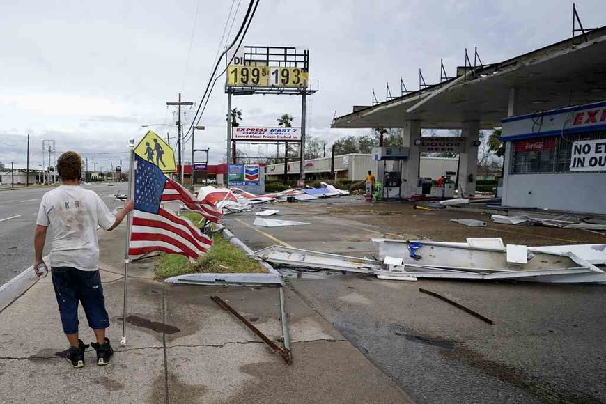 ELLITORAL_322342 |  Gerald Herbert Dustin Amos walks near debris at a gas station on Thursday, Aug. 27, 2020, in Lake Charles, La., after Hurricane Laura moved through the state. (AP Photo/Gerald Herbert)